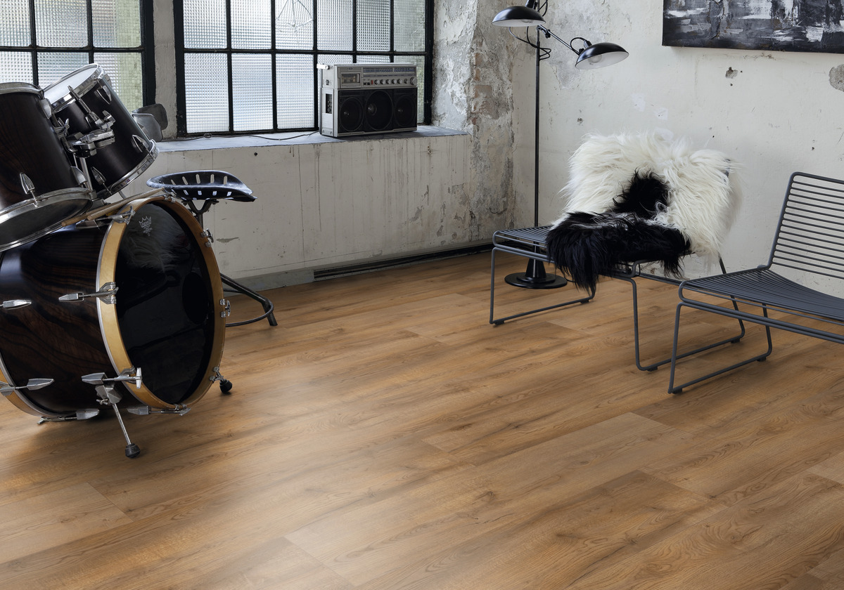 Raumgestaltung mit braunem Holzoptik Bodenbelag, minimalistischer Wand und Einrichtung wie Schlagzeug und Sitzgelegenheiten.