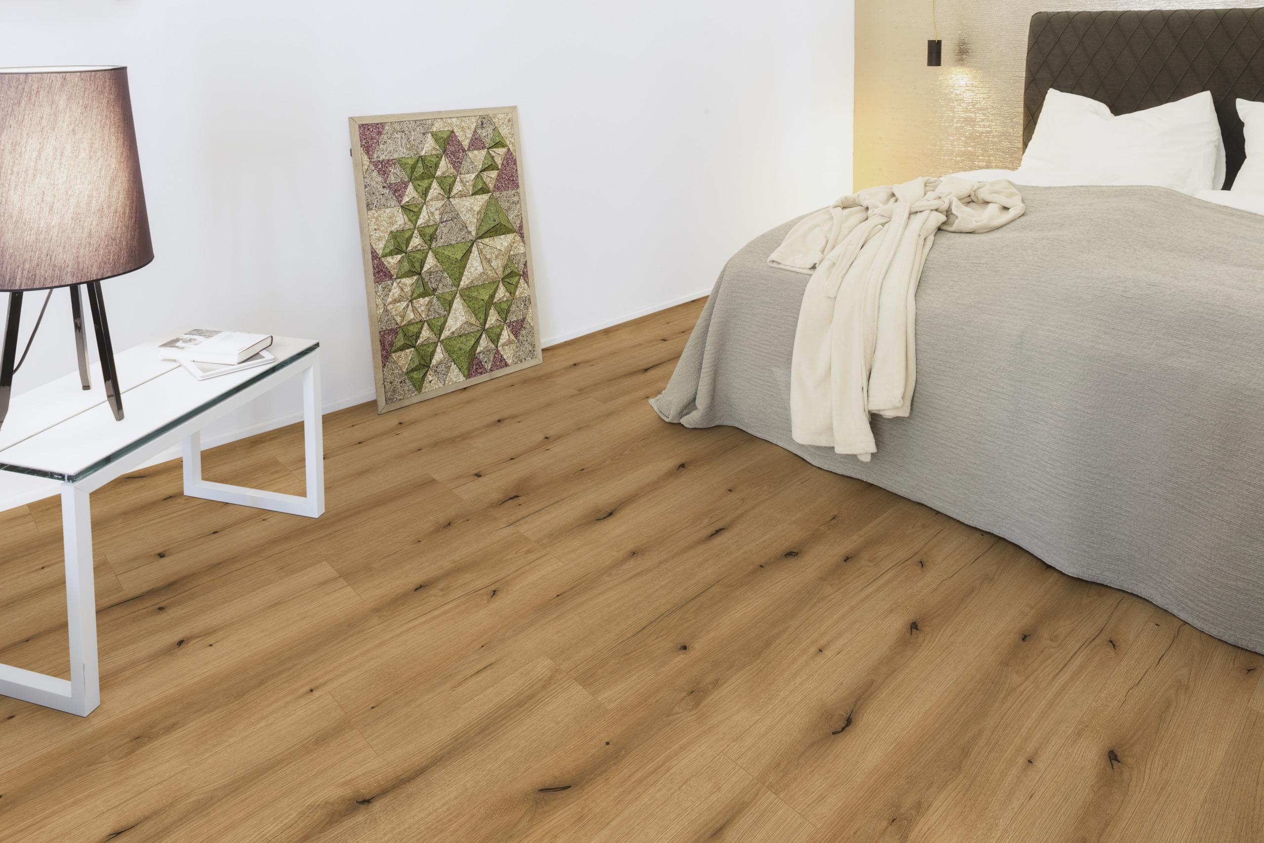 Gemütliches Schlafzimmer mit Holzboden, Wandgestaltung und Bett mit Decke. Stilvolle Raumgestaltung für Innenausbau und Bodenbeläge.