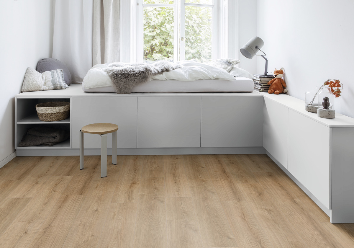 Raumgestaltung mit hellem Holzoptik-Bodenbelag und weißer Wandgestaltung, integriertem Sitzmöbel und Fenster.