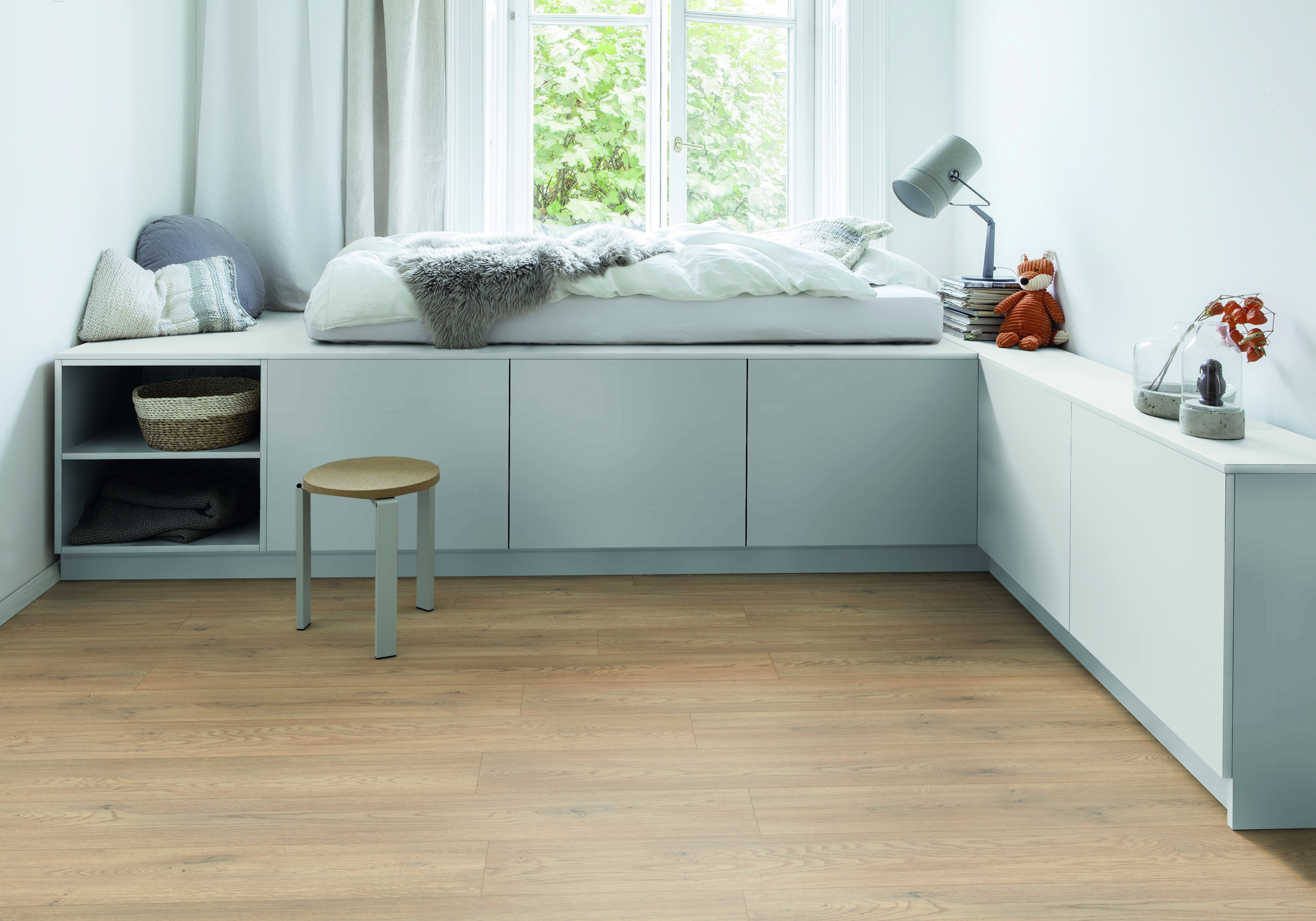 Heller Raum mit Holzoptik Bodenbelag, weißer Wandgestaltung und moderner Möblierung als Raumgestaltung.