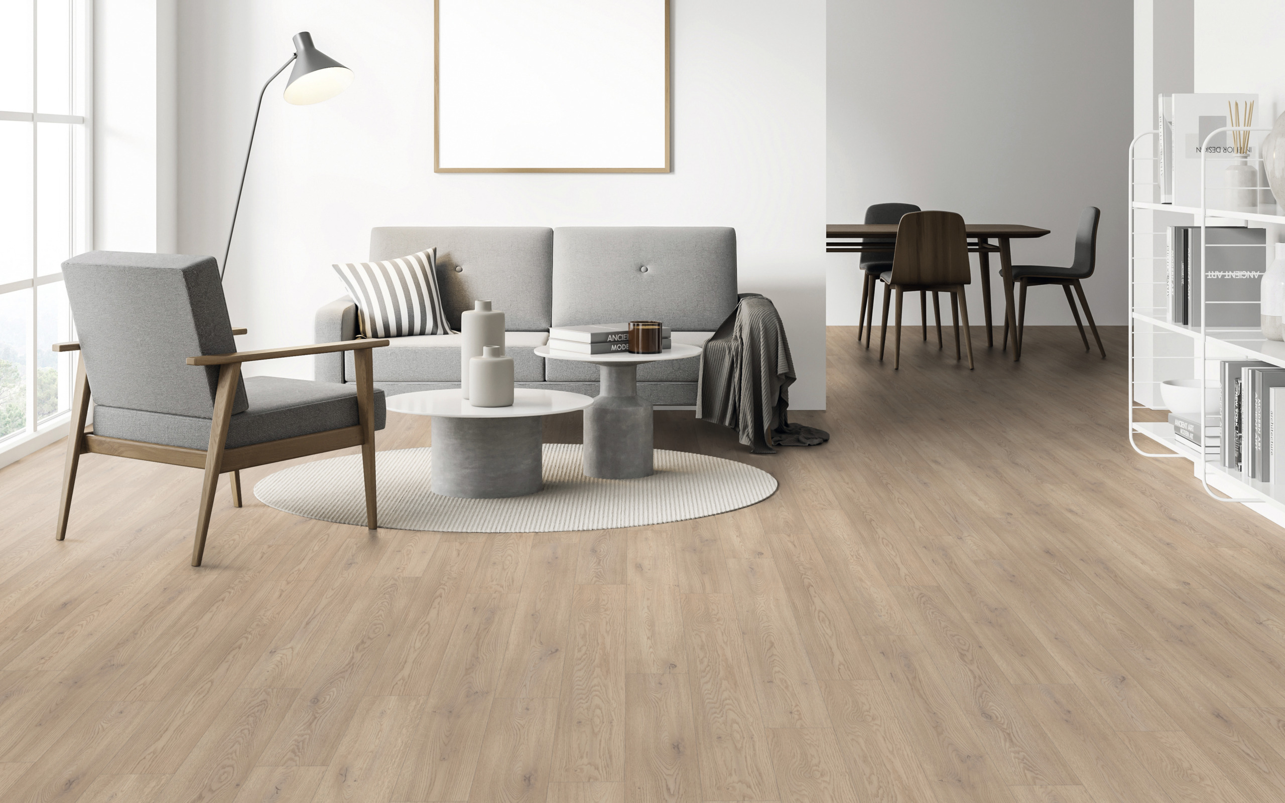 Moderne Raumgestaltung mit hellem Holzoptik Bodenbelag, grauer Sitzgarnitur, Esstisch und weißem Regal.