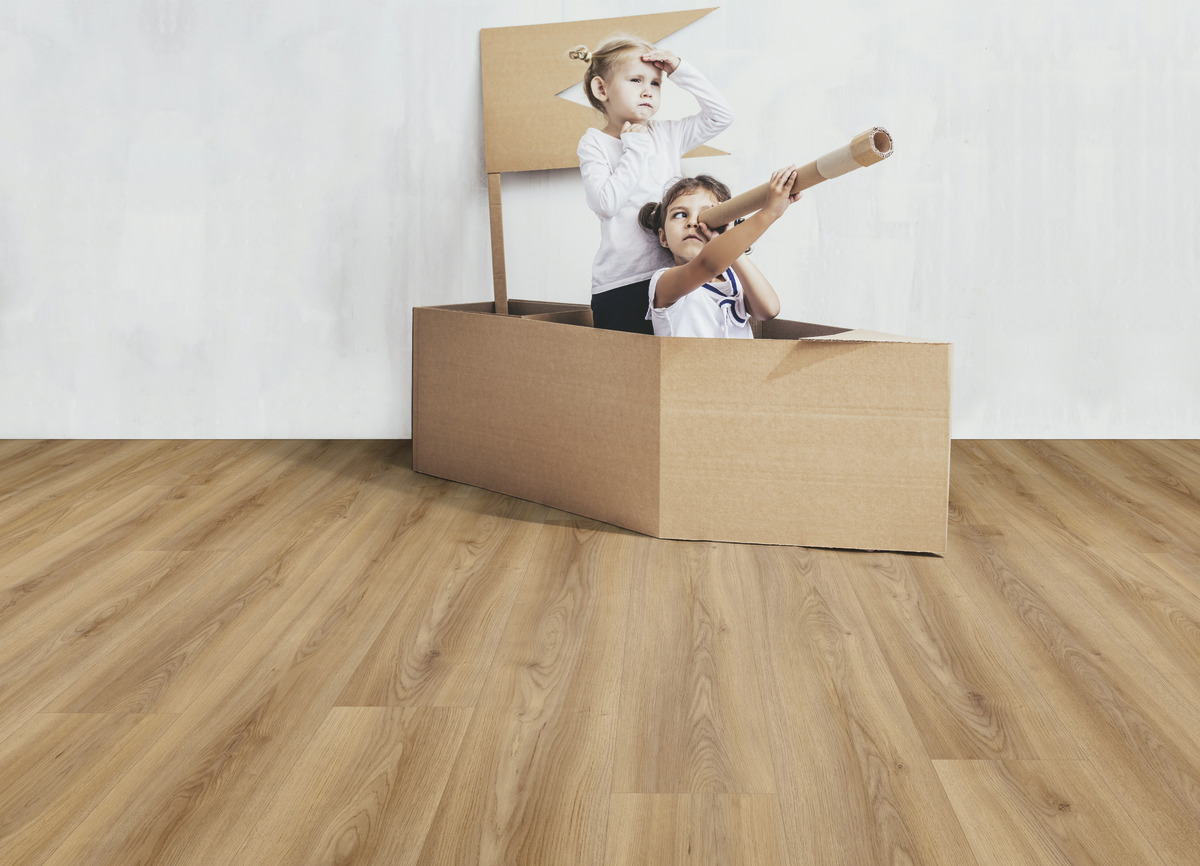 Bodenbelag mit Holzoptik in heller Ausführung und weißer Wand, als Kulisse für eine spielerische Raumgestaltung mit Karton.
