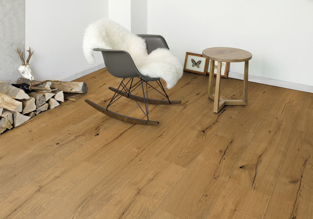 Landhausdielen mit Holzoptik in einem Raum mit Schaukelstuhl, Beistelltisch und Dekoration; Bodenbelag und Wandgestaltung.